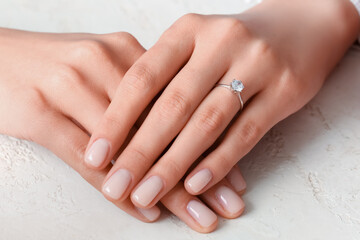 Woman with engagement ring on white background, closeup