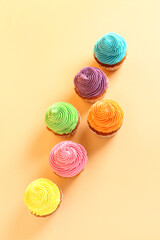 Tasty colorful cupcakes on orange background