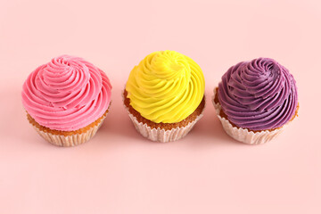 Tasty colorful cupcakes on pink background
