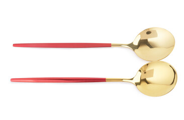 Golden spoons with red handles on white background
