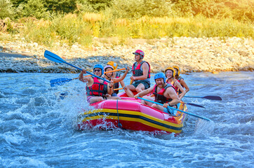team of cheerful travelers are rafting on a boat on a stormy river