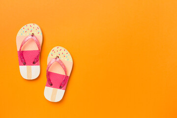 Bright flip flops on color background, top view