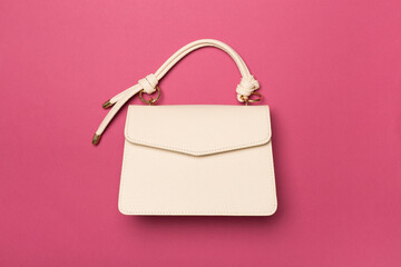Fashionable leather bag on color background, top view