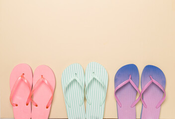 Many colorful flip flops on color background, top view