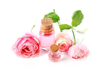 Bottles of cosmetic oil with rose extract and flowers on white background