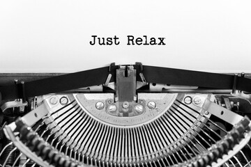 Just relax phrase closeup being typing and centered on a sheet of paper on old vintage typewriter mechanical