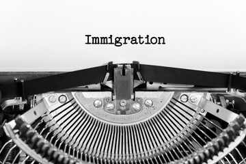 Immigration word closeup being typing and centered on a sheet of paper on old vintage typewriter mechanical