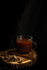 Mushroom tea. glass cup with a drink made from dried mushrooms. Dark photo