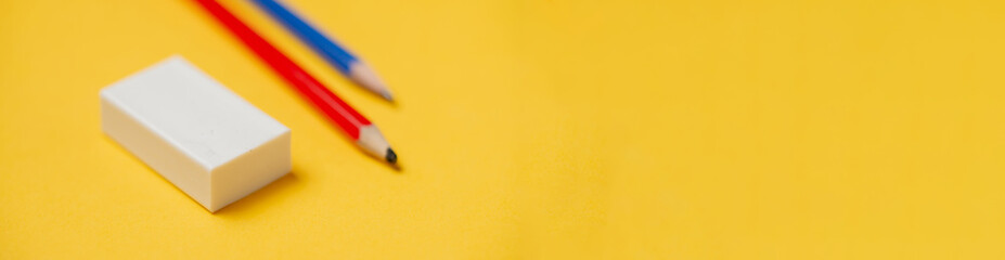 Eraser and pencils on a yellow background. Banner, place for text. Stationery.
