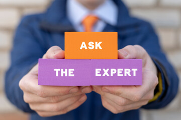 Businessman holding colorful blocks with inscription: ASK THE EXPERT. Concept of ask the expert....