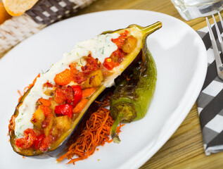 Delicious baked eggplant stuffed with vegetable mix served with tzatziki sauce..