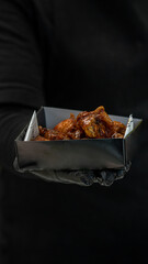Fast food, Chef hand showing basket of spicy bbq wings