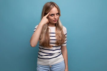 Fototapeta premium attractive well-groomed girl shows a gesture to think with her head on a blue isolated background