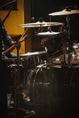Close-up of drummer drumsticks with a drum set.