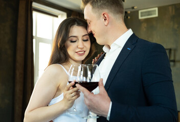 Bride and groom hold in their hands glasses with wine