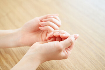 爪の状態を確かめる女性の手元