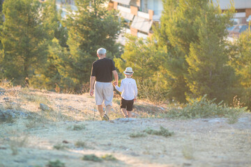Grandfather and grandson enjoying outdoor, smiling and hugging. Concept of friendly family.