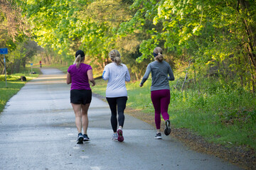 Three women exercise running on the street