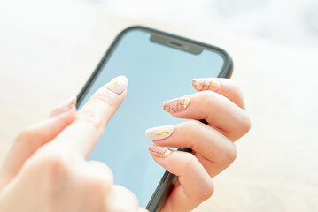 スマートフォンを操作する女性の手元