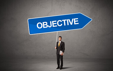 Obraz premium Young business person in casual holding road sign