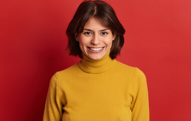 Content ethnic lady smiling at camera in red studio