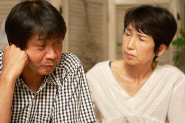 自宅で落ち込む中年男性