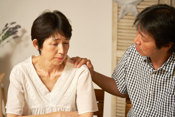 自宅で落ち込む中年女性