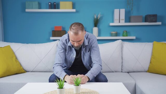 Angry man banging his head on the table.