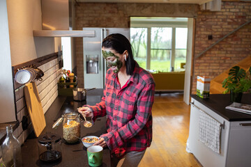 Young adult woman preparing coffee and cereal in the morning