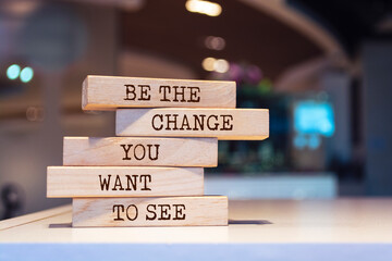 Wooden blocks with words 'Be the change you want to see'.