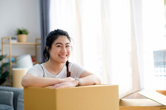 Happy woman smiling at home during move with boxes