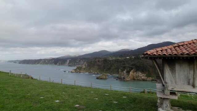 Aerial shot of a horreo, traditional granary from the north of Spain in a cliff next to the sea.