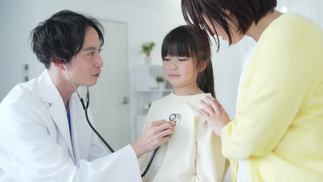 入院している女の子を診察する医師　小児科医