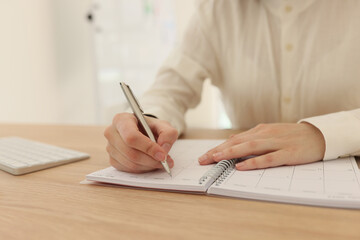 Woman planning business and taking notes in office