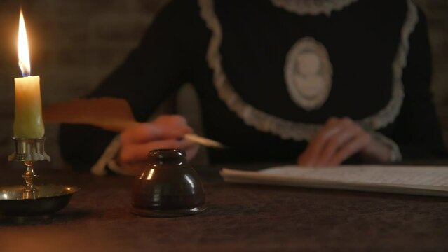 Woman writing with a quill pen finishes letter