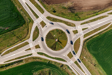 Roundabout intersection road traffic with many cars, aerial shot from drone pov