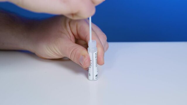 Squeeze dropper bottle with solution and take out swab sample for home-testing