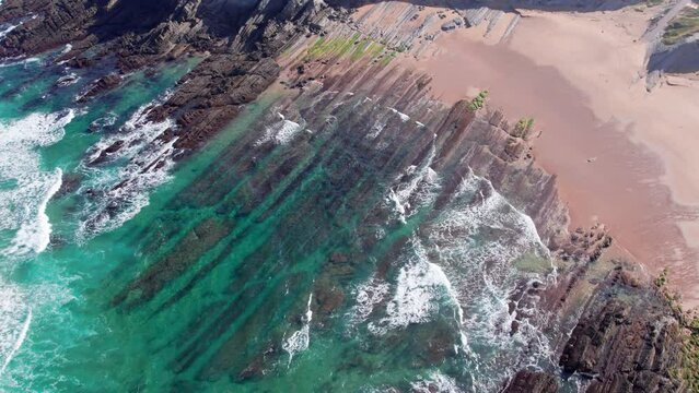 Waves Crashing And Water Washing On Ridges Of Soar Cliff, Playa de Tagle