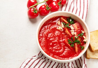 Tomato soup on white table, top view