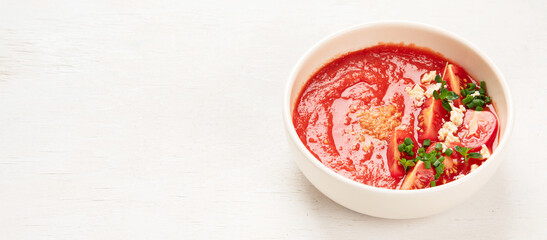 Tomato soup on white table, top view