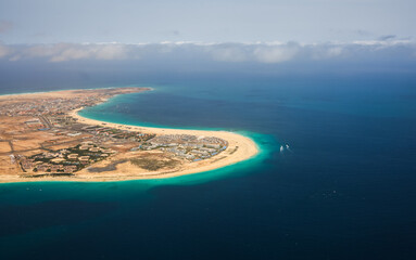 Fototapeta na wymiar Cabo Verde beach resorts and hotels. Aerial view of Sal Island from the middle of Atlantic Ocean during a sunny day with blue sky and turquoise blue water color.
