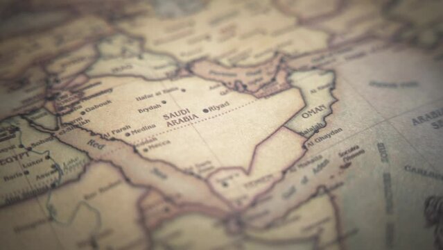 Saudi Arabia on a vintage political world map. Slow motion, tracking arc shot. 