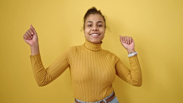 Young african american woman smiling confident dancing over isolated yellow background