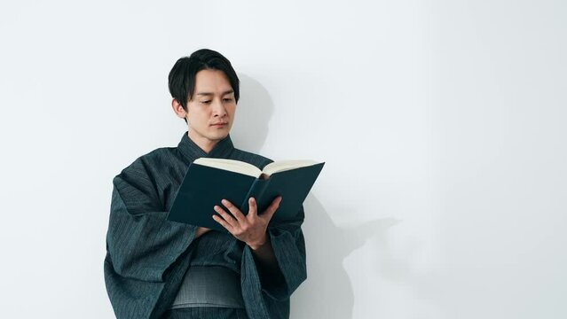 和服で本を読む男性