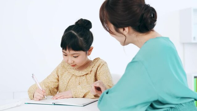 女の子に勉強を教える女性