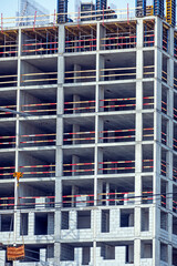 Fragment of the facade of a multi-storey residential building under construction on a spring day