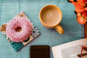 Papier Peint photo Lavable Bar a café Break concept. Pink glazed donut on breakfast table, cup of coffee, book and mobile phone