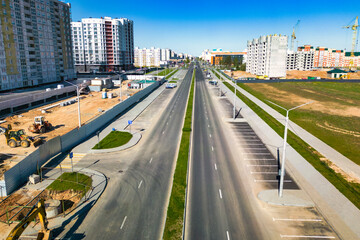Obraz premium Construction of new roads and sidewalks in the city. View from above. Construction of a new modern area. Improvement of the territory and access roads. Road works from above.