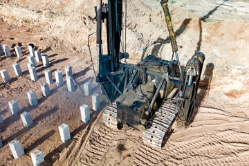 Pile driving machine. Diesel hammer pile driving machine working on construction site. Preparation of the pile foundation for the construction of the building. - Powered by Adobe