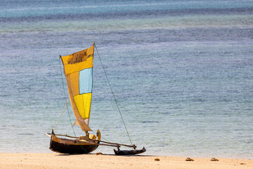 Tranquil scene of a wooden fishing boat resting on the golden sands of Nosy Ve, Madagascar